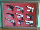 2:Marcos expositores con pistolas en miniatura.