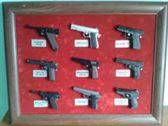 2:Marcos expositores con pistolas en miniatura.